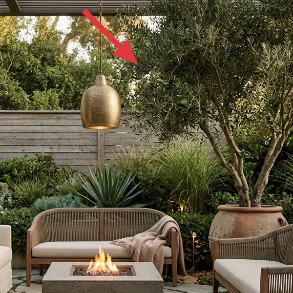 A hammered brass pendant light hanging over an outdoor patio, symbolizing ambient string lights.
