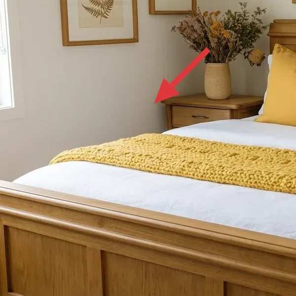 Beige vase with dried stems on a bedside surface