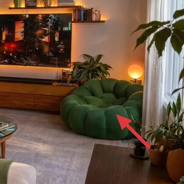 Green tufted rounded sofa on the right side of the living room